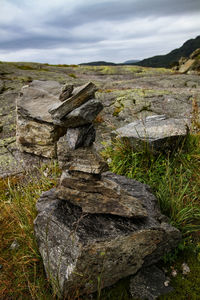 Stack of rocks on land against sky
