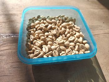 High angle view of coffee beans in container on table