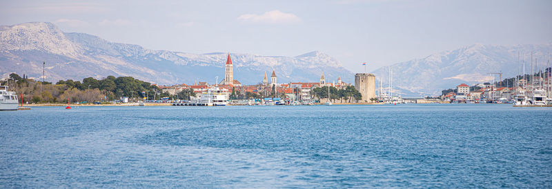 View of buildings by sea against sky