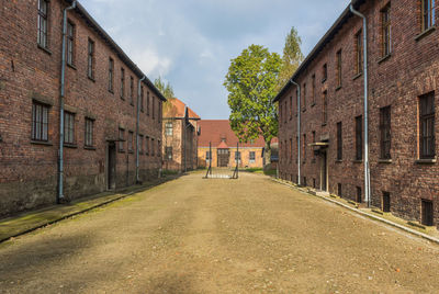 Empty road amidst buildings against sky