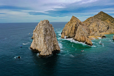 Panoramic view of rock formation in sea against sky