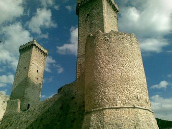 Low angle view of tower against cloudy sky