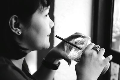 Thoughtful woman having drink in disposable cup while looking away