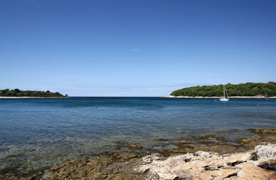 Scenic view of sea against clear blue sky