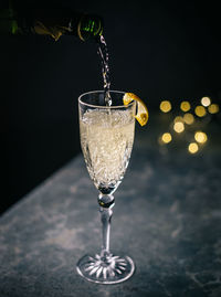 Close-up of bottle pouring champagne into crystal champagne flute