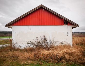Abandoned house on field against sky