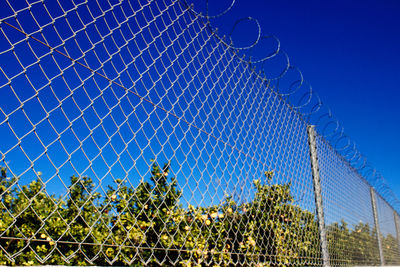 Chainlink fence against clear blue sky