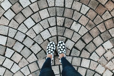 Low section of woman standing on footpath