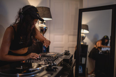 Fashionable young woman playing music at home