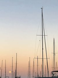 Sailboats in sea at sunset