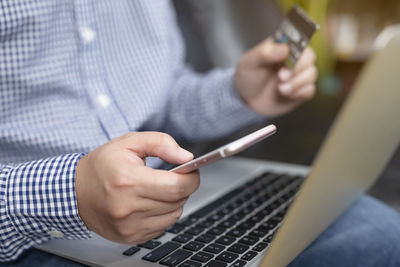 Midsection of man using mobile phone