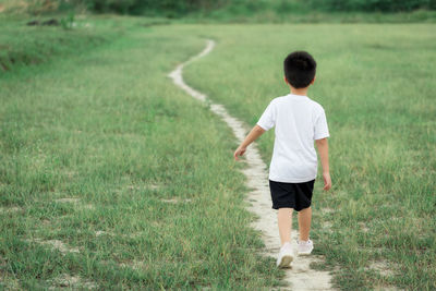 Rear view of boy on field