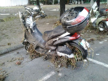 Abandoned motorcycle on street in field