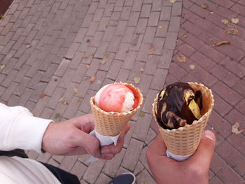 Midsection of man holding ice cream on street