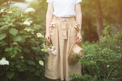 Midsection of woman standing on field