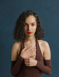 Portrait of young woman against black background