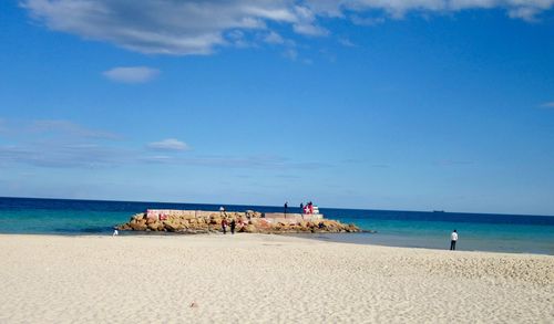 Scenic view of beach against blue sky