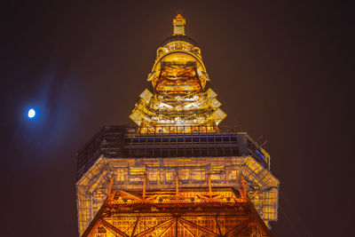 Low angle view of illuminated building against sky at night