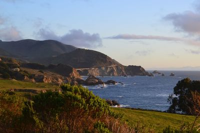 Scenic view of sea and mountains against sky