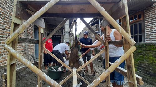 People standing at construction site against building