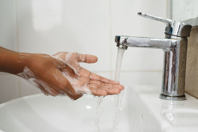 Cropped image of person washing hands