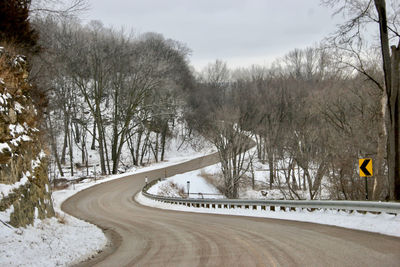 Road amidst bare trees during winter