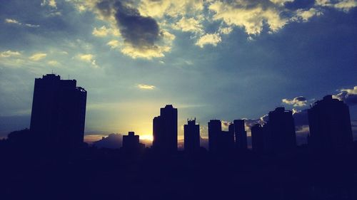 Silhouette cityscape against sky during sunset