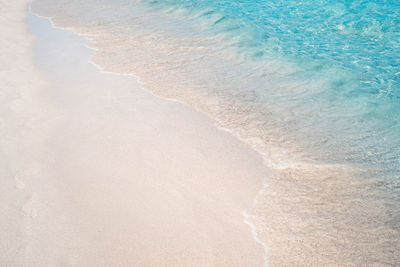 Crystal clear water rolling on white sand beach in san teodoro.