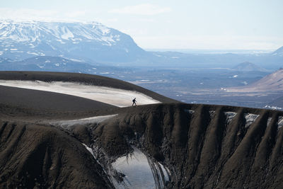 Distant view of man walking on mountain