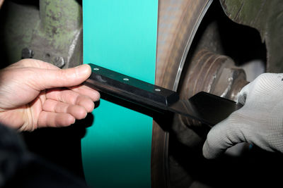 Cropped hand of man working with machinery in factory