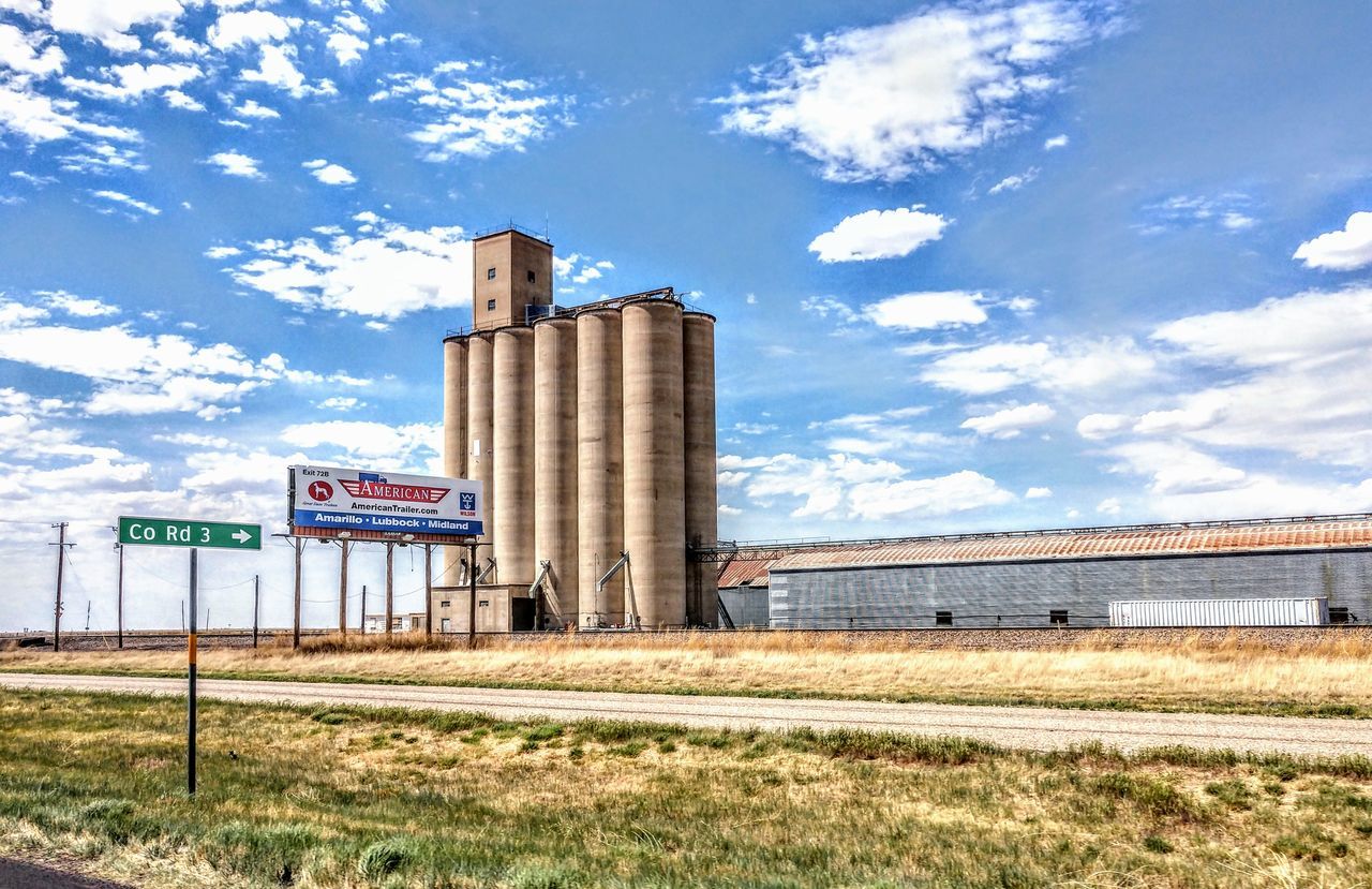 sky, cloud - sky, architecture, day, nature, built structure, no people, building exterior, grass, sign, text, land, field, western script, outdoors, landscape, communication, plant, history, the past