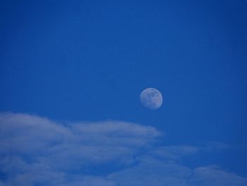 Low angle view of moon against blue sky