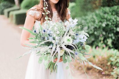 Midsection of bride holding bouquet