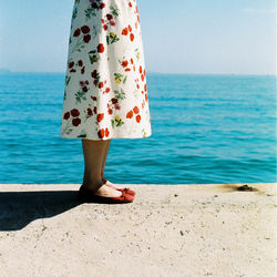 Low section of woman standing on beach