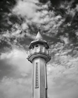 High section of an old minaret against cloudy sky