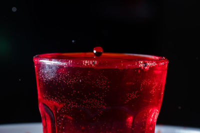 Close-up of red wineglass against black background