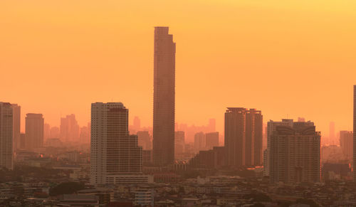 Air pollution. smog and fine dust of pm2.5 covered city in the morning with orange sunrise sky. 