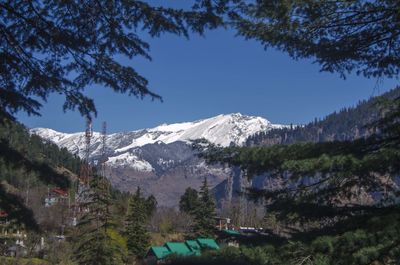 Scenic view of snowcapped mountains against blue sky