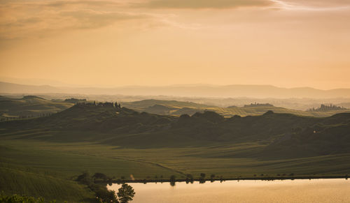 Scenic view of agricultural field against sky during sunset