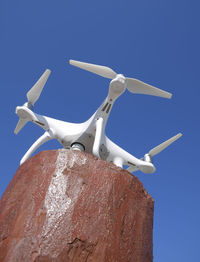 Low angle view of wind turbine against blue sky