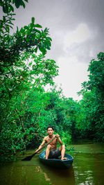 Full length of shirtless man in lake against trees