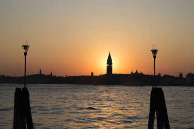 Grand canal by silhouette san giorgio maggiore against clear sky during sunset