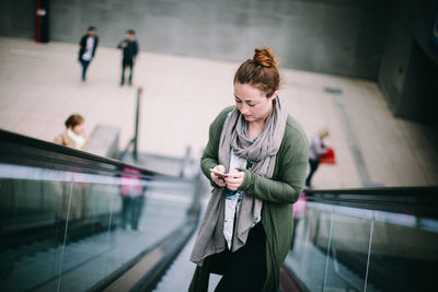Woman looking at camera while standing on bus