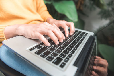 Midsection of woman using laptop