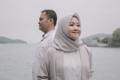 Portrait of young man standing against sea