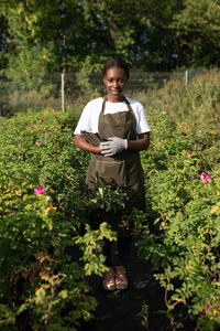 Black gardener with tablet in field