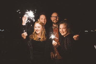 Happy friends holding sparklers