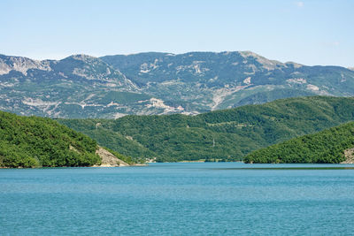 Scenic view of sea and mountains against sky