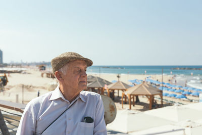 Close-up of senior man at beach against clear sky