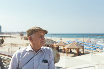 Portrait of man with hat on beach against sky